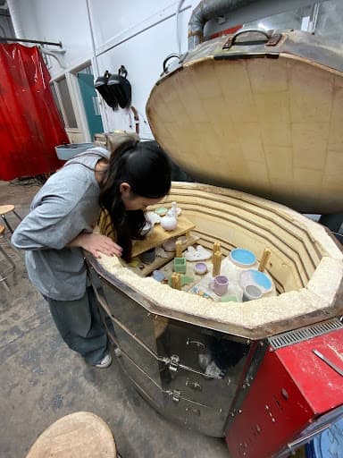 RuiXuan Xu loading glazed work into a kiln